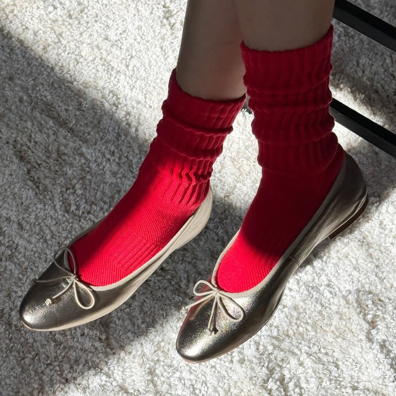 A person wearing the Ballet Socks in Strawberry with a pair of silver flats.