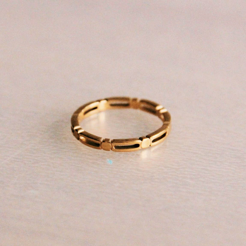 A gold stainless steel ring patterned with cubs and long ovals.