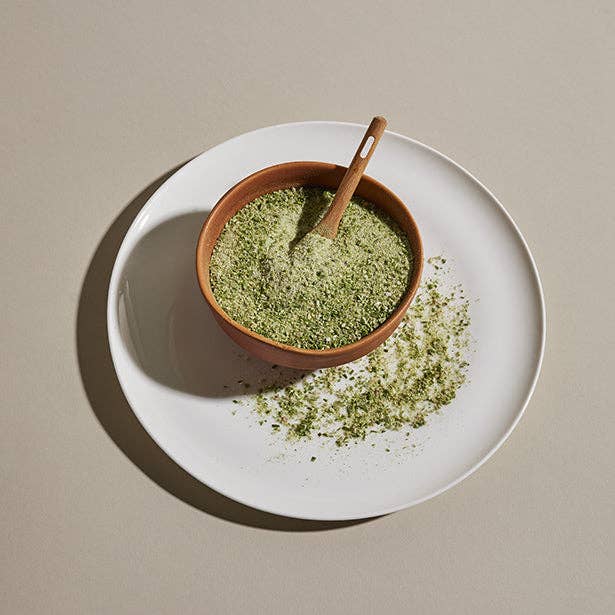 A ceramic bowl and spoon filled with Lakeshore Shallot & Herb Seasoning.