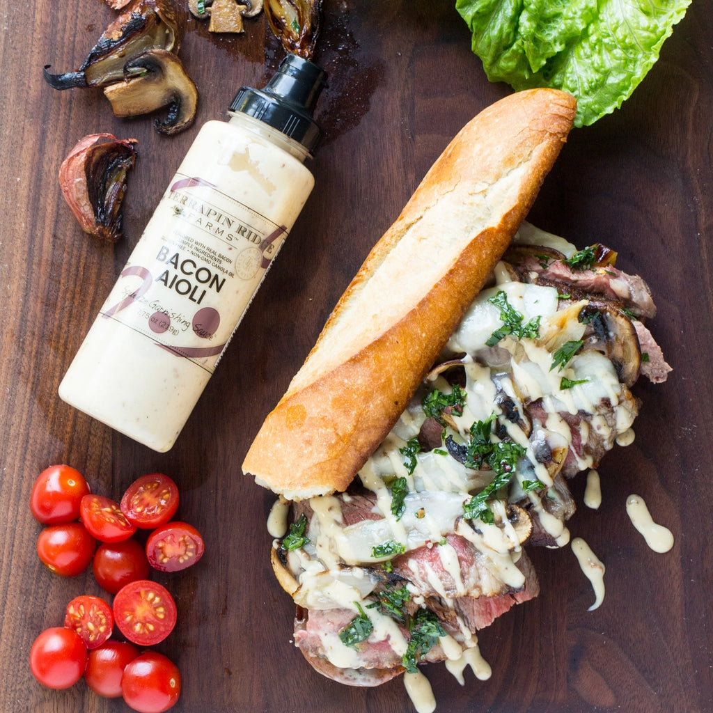 A baguette sandwich with meat, mushrooms, and bacon aioli.