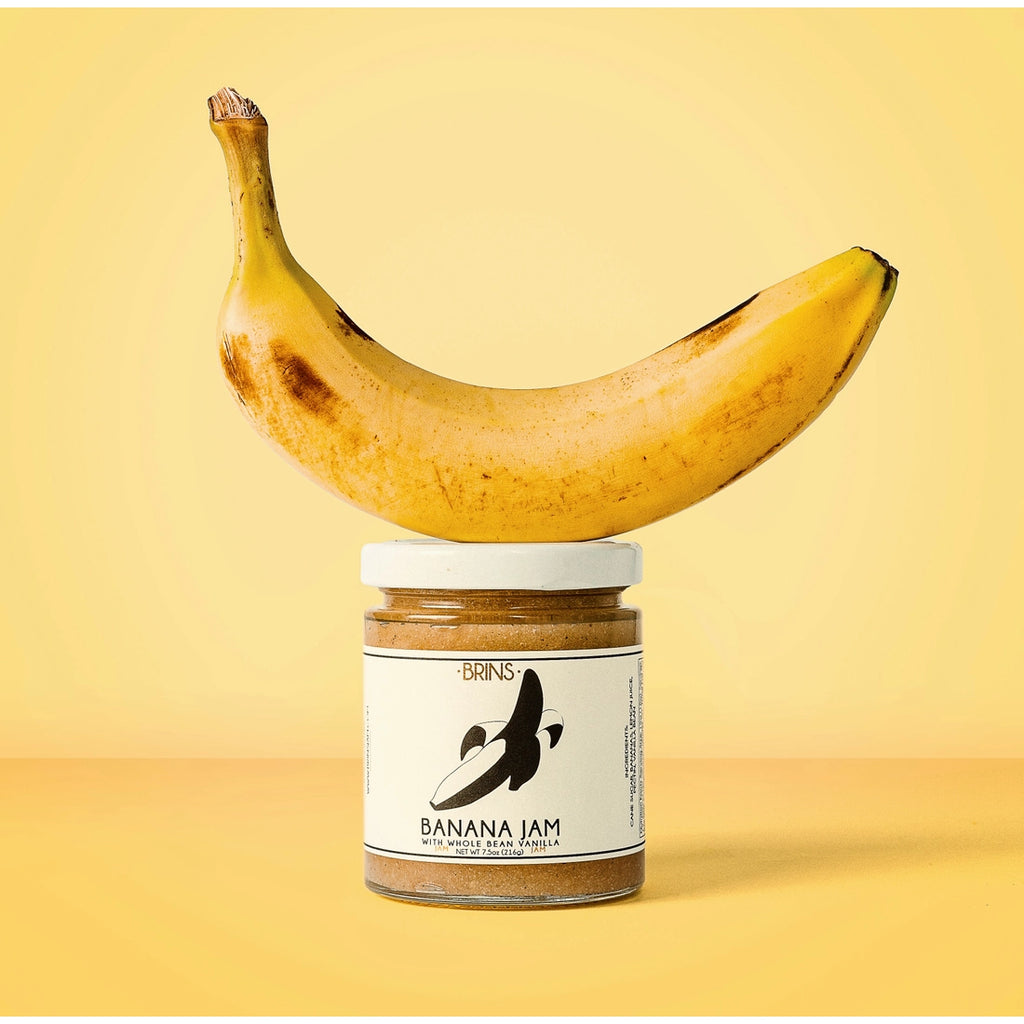 A jar of Banana Jam with a banana balancing on its lid.