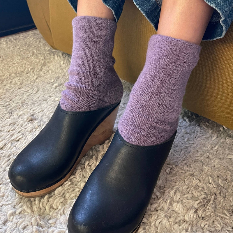  person wearing the Cloud Socks in Plum with black clogs.