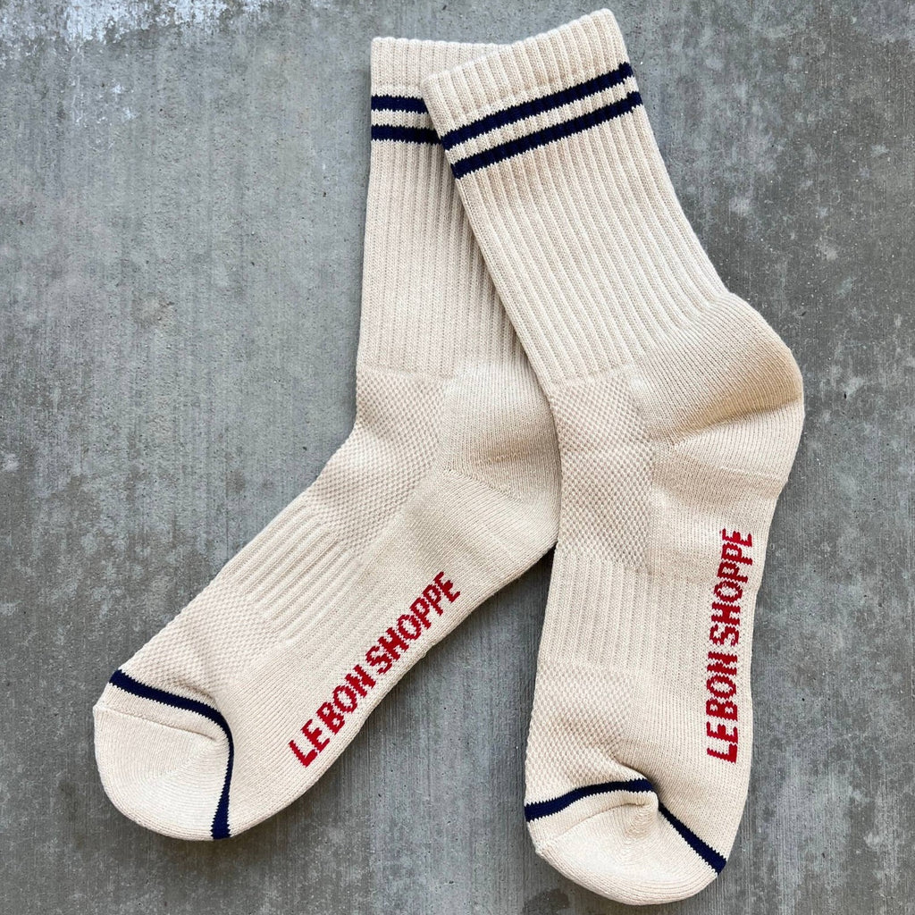 Long cream socks with navy blue stripes above the ankle and at the toes.