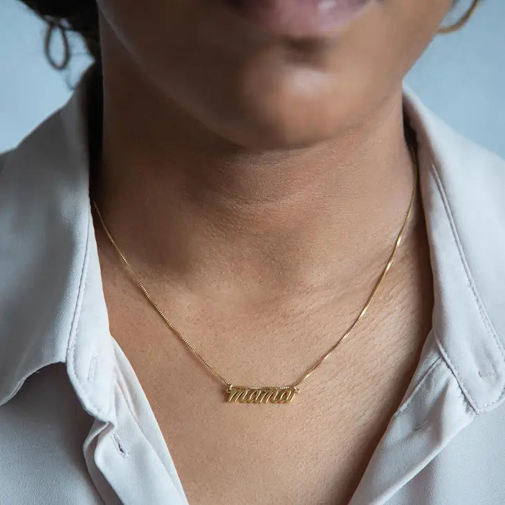 A person wearing the MAMA necklace with a white button up shirt.