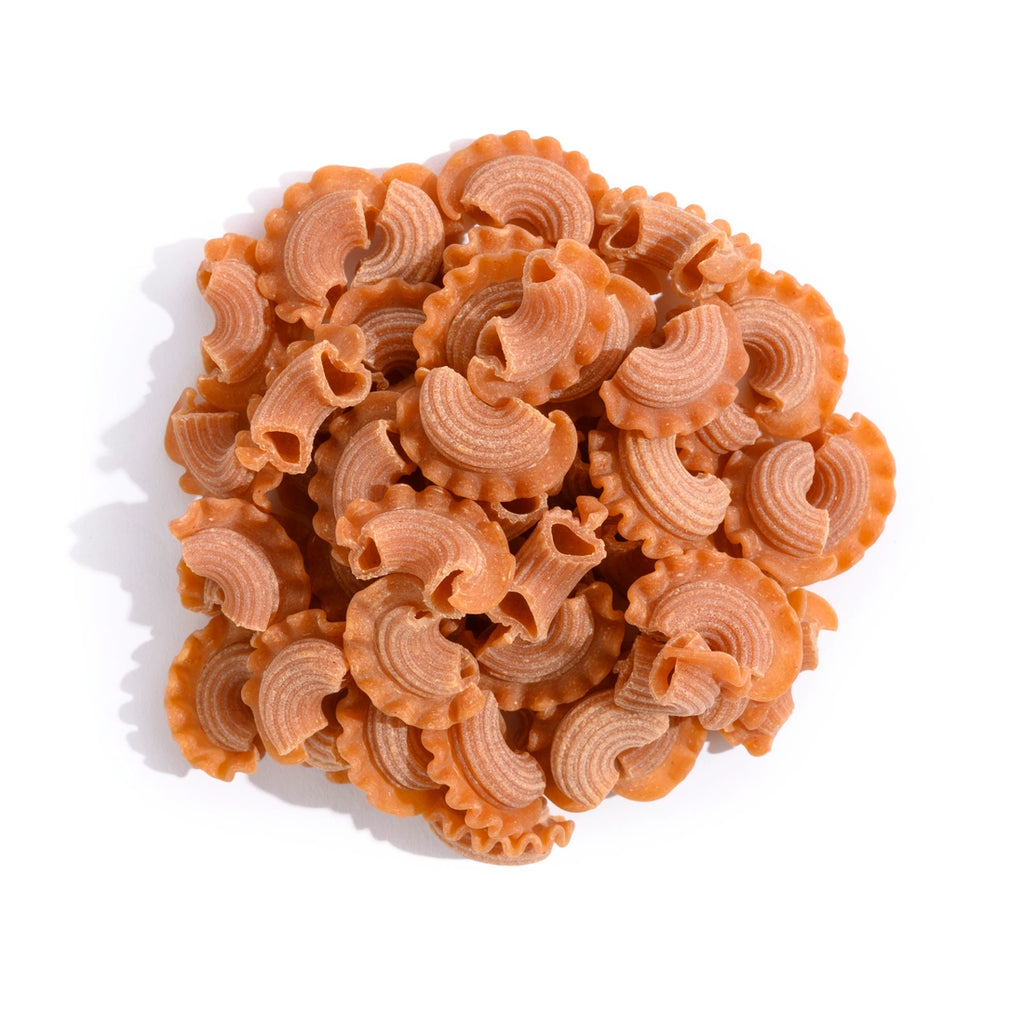 A pile of orange pasta in the shape of a mohawk hairstyle.