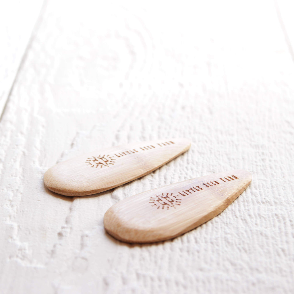 Two wooden spatula applicators with "Little Seed Farm" engraved in it.