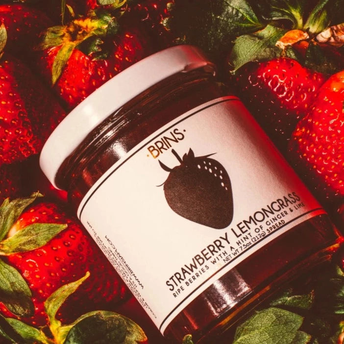 A Strawberry Lemongrass jar amidst strawberries.